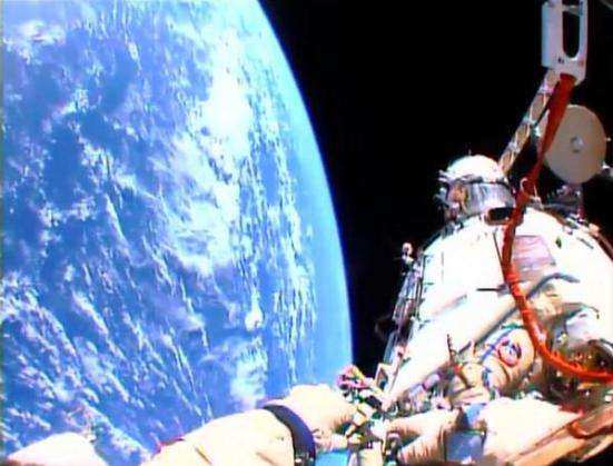 Oleg Kotov with the Olympic torch above the planet Earth | via Twitter